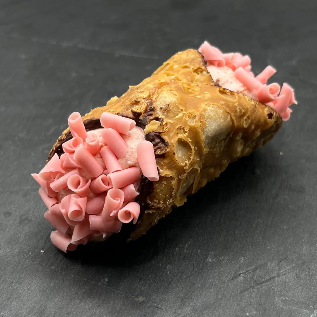 Geniet van de heerlijke Cannoli Fragola - Aardbei, ambachtelijk gevuld met romige aardbei-vulling. Perfect voor bij een bakje koffie!