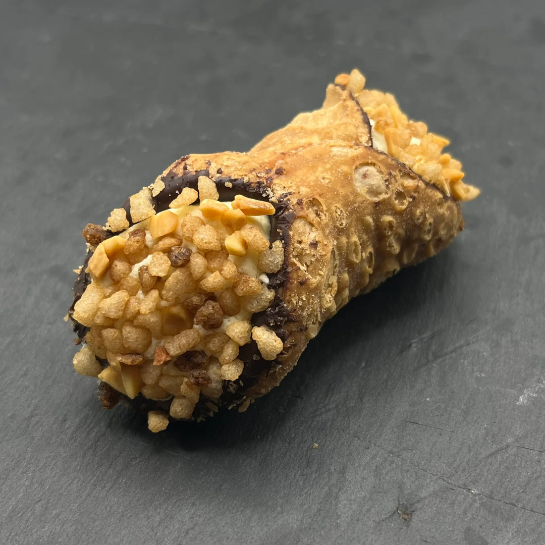 Heerlijke Cannoli met Banaan van Holy Cannoli, ambachtelijk gevuld met romige banaan-vulling, perfect als zoete traktatie. Geniet van de Italiaanse smaak!
